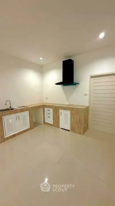 Modern minimalist kitchen with sleek cabinetry and built-in range hood