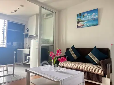 Charming living room with modern decor and kitchenette in a cozy apartment.