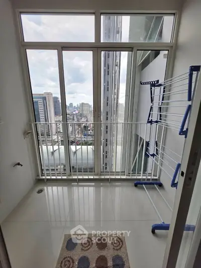 High-rise condo balcony with city view and drying rack