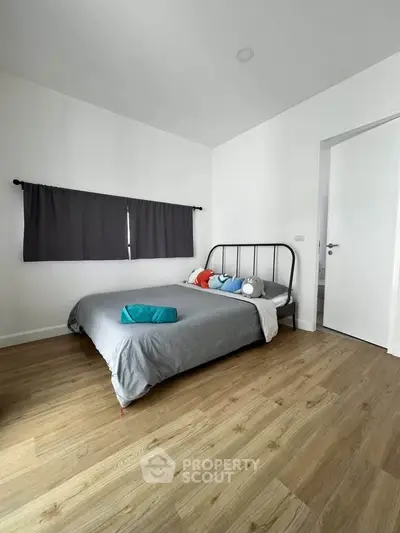 Cozy bedroom with modern decor and wooden flooring, perfect for relaxation.