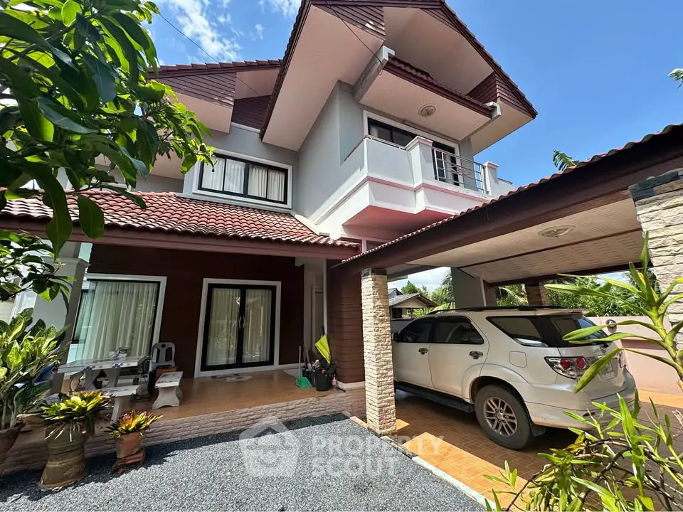 Charming two-story house with carport and lush garden, perfect for family living.