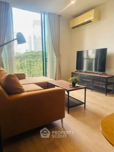 Modern living room with large window and city view, featuring stylish furniture and a cozy ambiance.