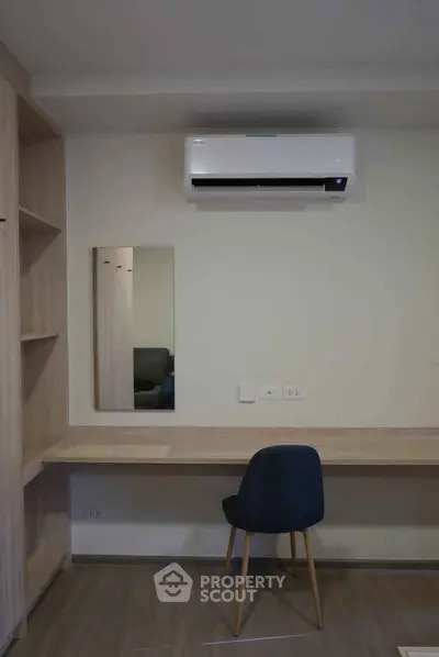 Modern study area with built-in desk, chair, and air conditioning in a stylish apartment.