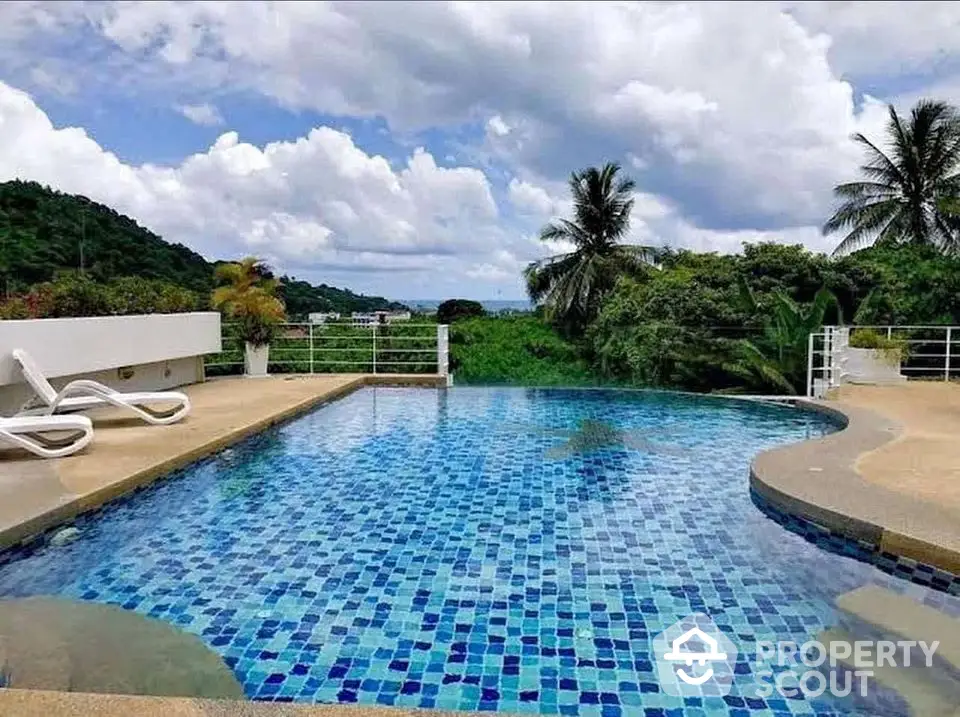 Stunning infinity pool with ocean view and lush greenery, perfect for luxury relaxation.