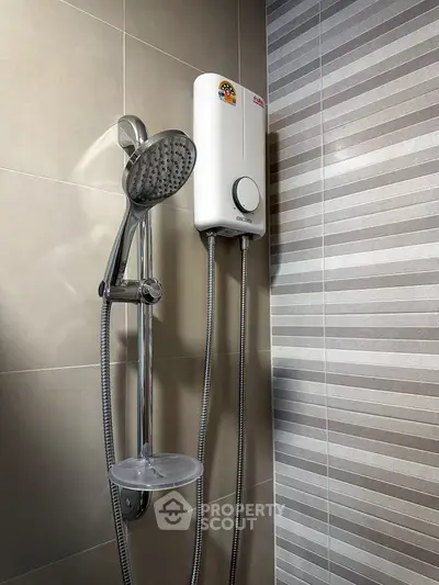 Modern bathroom with sleek showerhead and water heater, featuring stylish tiled walls.