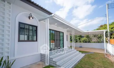 Charming modern house exterior with stylish covered porch and lush green lawn.
