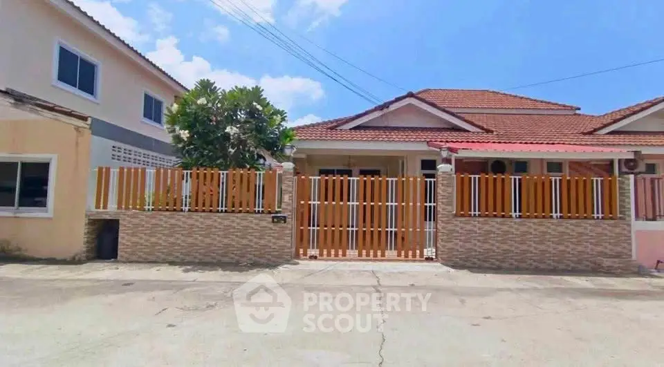 Charming suburban house with tiled roof and fenced front yard, perfect for family living.