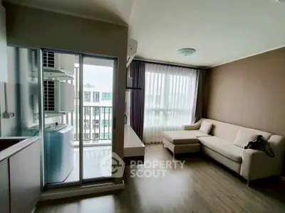 Modern living room with balcony access and stylish furniture in a high-rise apartment.