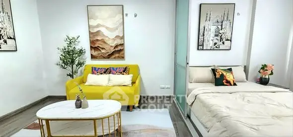 Modern studio apartment with stylish decor, featuring a cozy bed and vibrant yellow sofa.