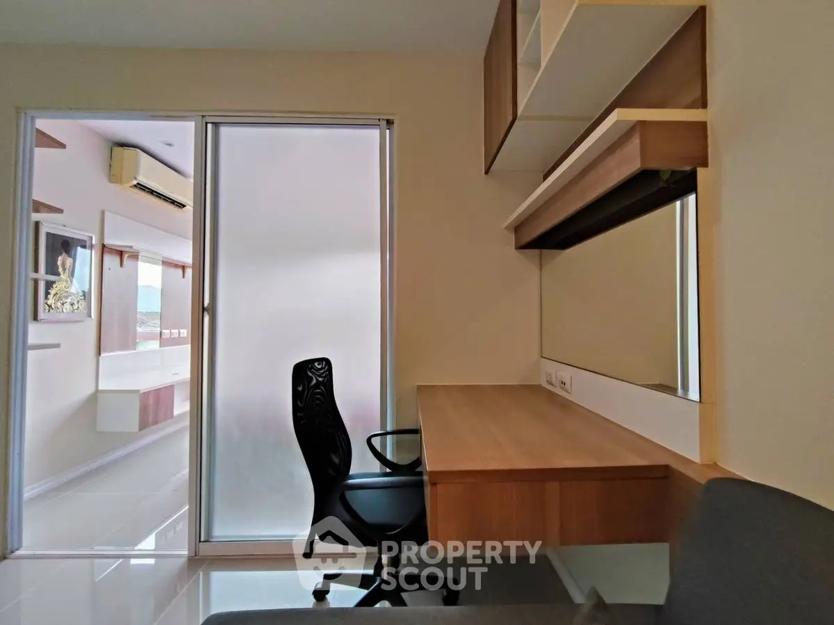 Modern study room with built-in desk and chair, featuring sleek design and ample natural light.
