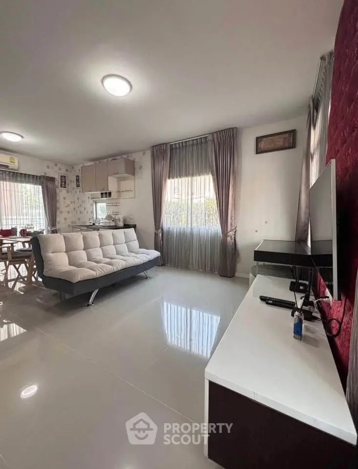 Modern living room with sleek furniture and large windows for natural light.