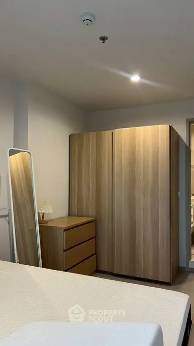Modern bedroom with sleek wooden wardrobe and cozy lighting