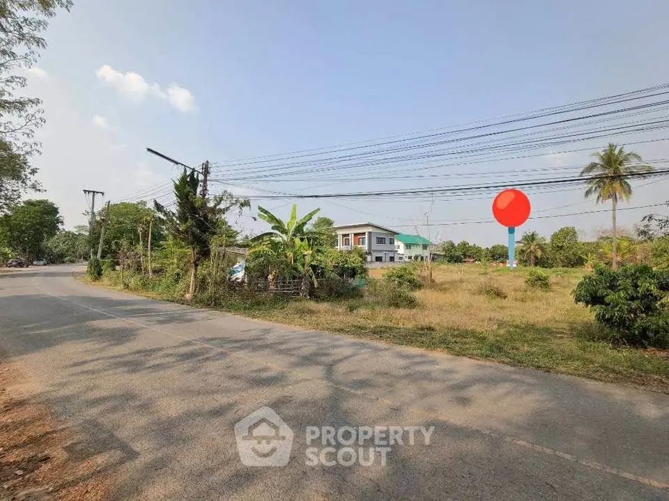 Scenic view of a suburban road with a modern house and lush greenery, perfect for tranquil living.