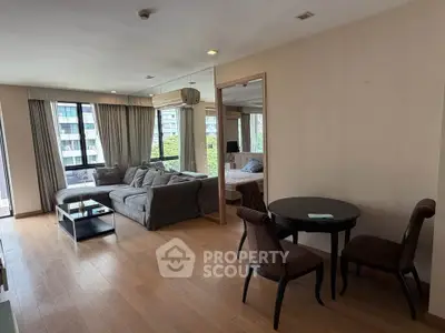 Spacious living room with modern furniture and large windows in a stylish apartment.