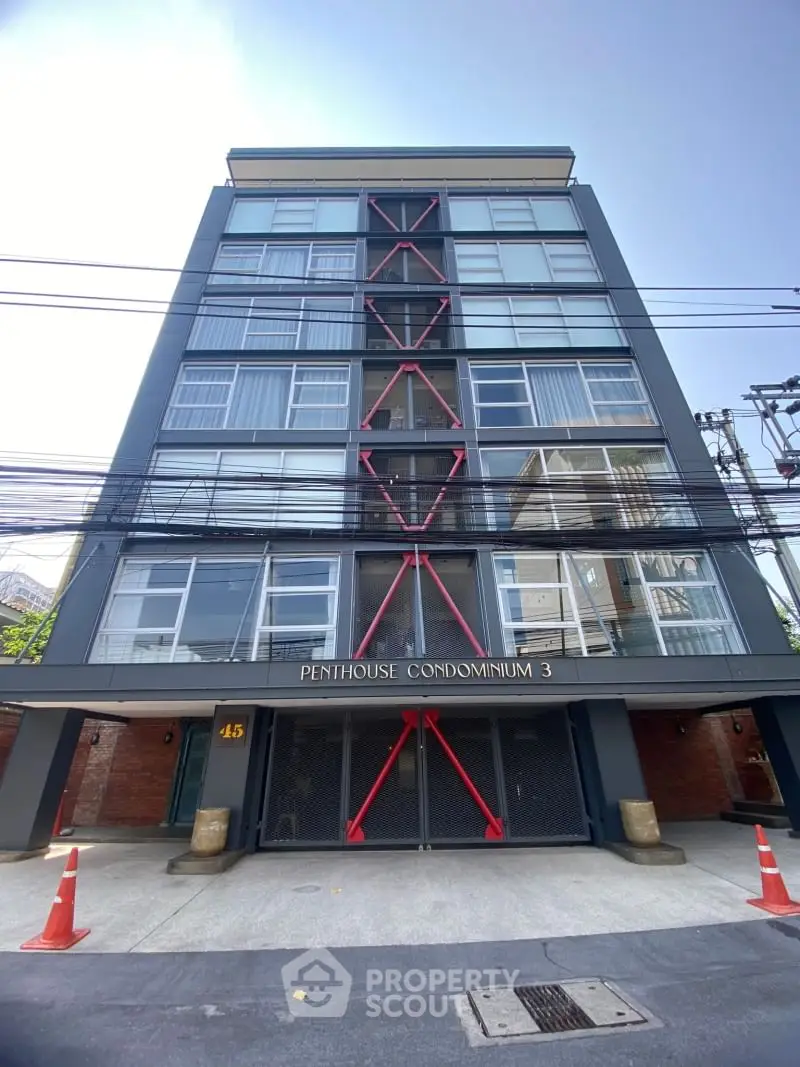Modern penthouse condominium exterior with unique architectural design and ample parking space.