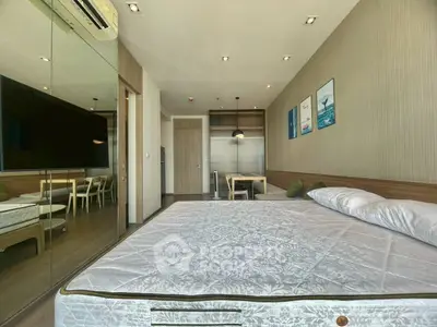 Modern bedroom with mirrored closet and dining area in open-plan apartment