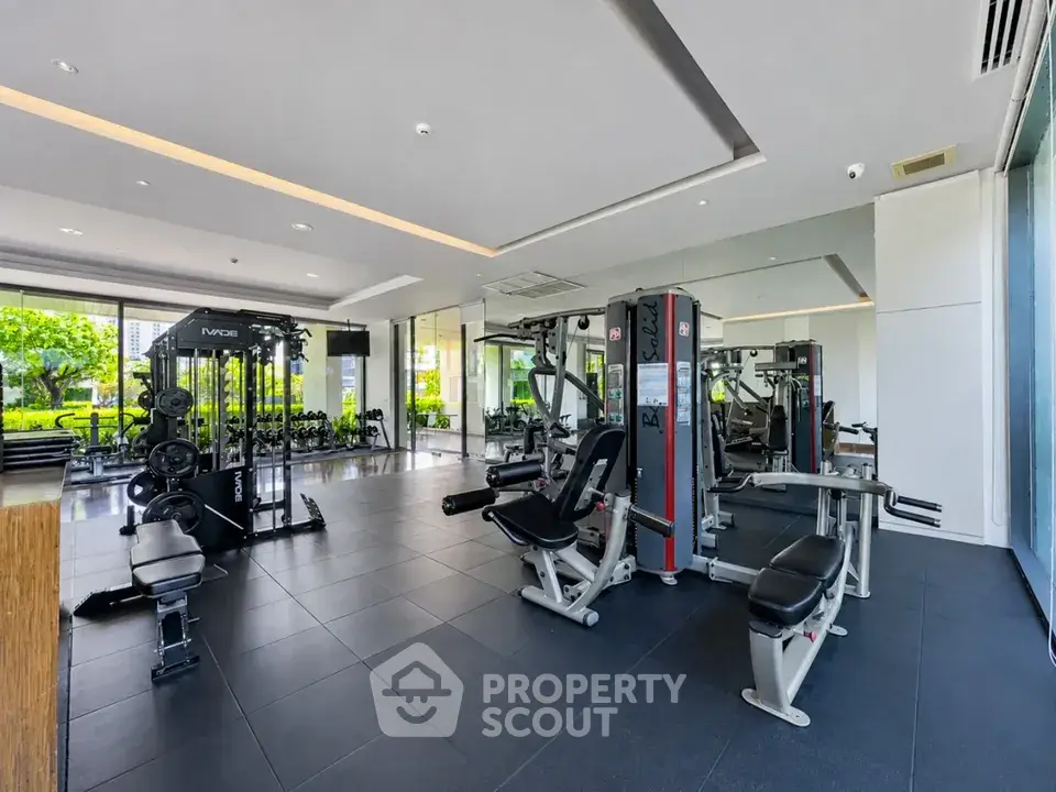 Modern gym with state-of-the-art equipment and large windows offering garden views.