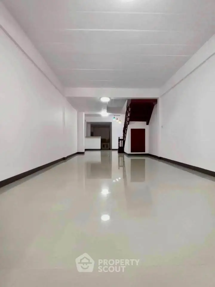 Spacious open-plan living area with sleek flooring and modern staircase, perfect for customization.