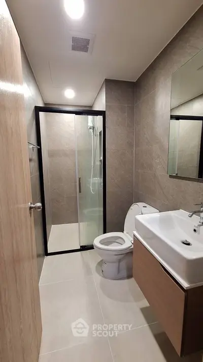 Modern bathroom with glass shower and sleek fixtures in contemporary apartment