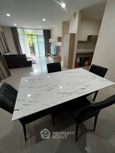 Spacious modern living room with elegant dining area and large windows for natural light.