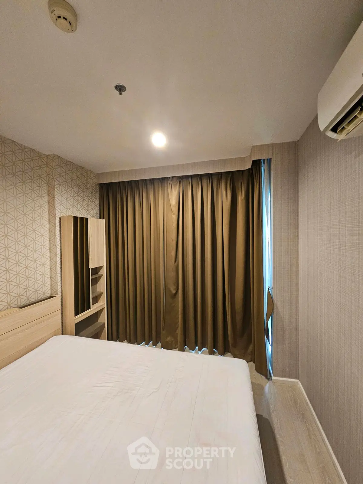 Cozy bedroom with modern decor and air conditioning, perfect for relaxation.