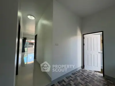 Spacious hallway with modern design leading to a poolside view