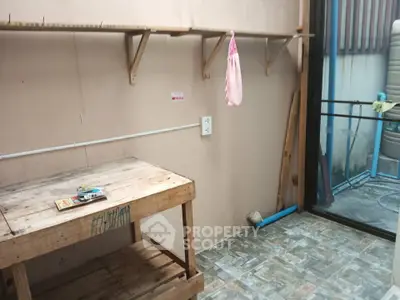 Rustic utility room with wooden shelves and workbench, ideal for storage or DIY projects.