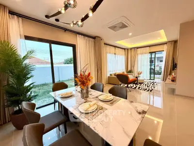 Luxurious open-plan living and dining area with modern decor and large windows.