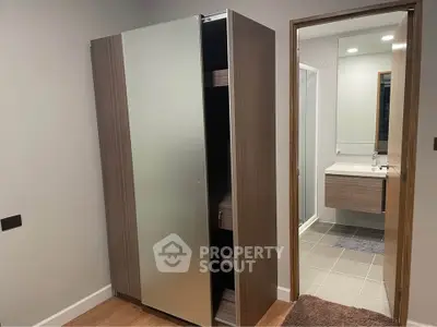 Modern interior with sleek wardrobe and bathroom view, showcasing contemporary design and functionality.