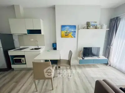 Modern open-layout kitchen and living area with sleek furniture and natural light.