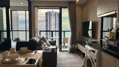 Modern living room with ocean view, featuring sleek furniture and a washing machine, perfect for urban living.