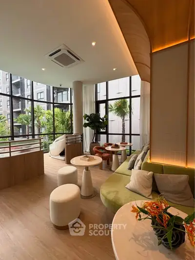 Modern living room with large windows and stylish furniture, offering a serene garden view.