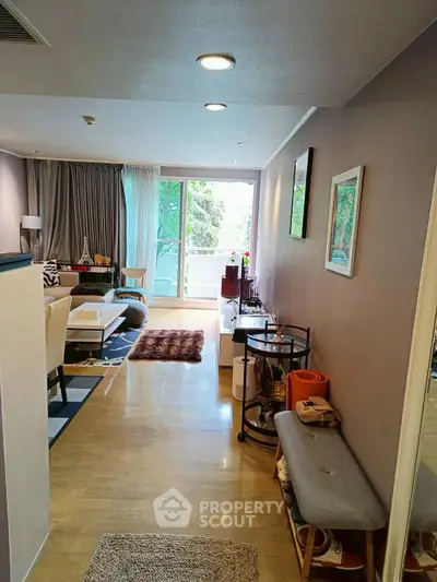 Spacious living room with modern decor and large windows opening to a balcony.