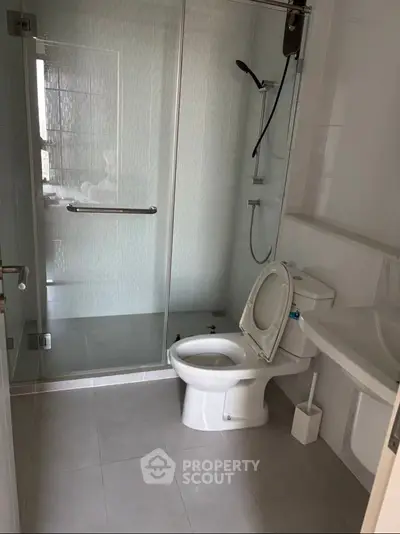 Modern bathroom with glass shower and sleek fixtures in a contemporary apartment.