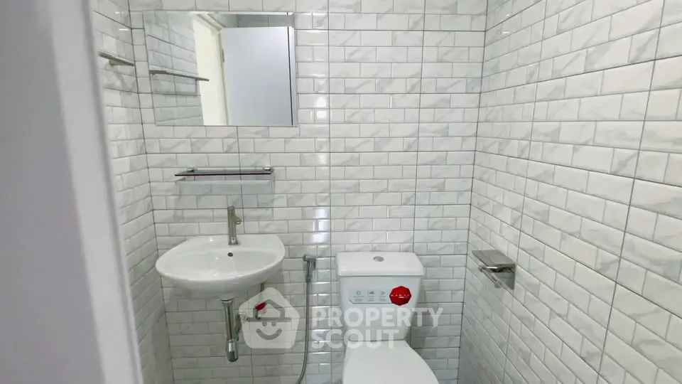 Modern bathroom with white subway tiles and compact fixtures