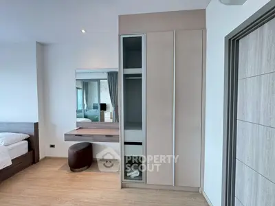 Modern bedroom with sleek wardrobe and stylish vanity in a contemporary apartment.