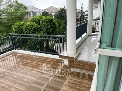 Spacious balcony with modern tiles and lush greenery view, perfect for relaxation.