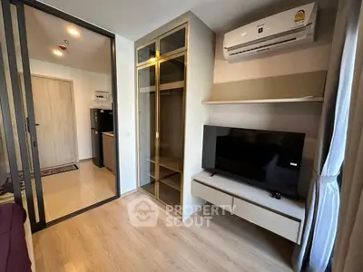 Modern living room with TV, air conditioning, and glass cabinet in stylish apartment.