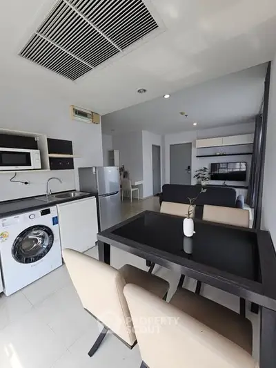 Modern open-plan kitchen and dining area with sleek appliances and stylish furniture.