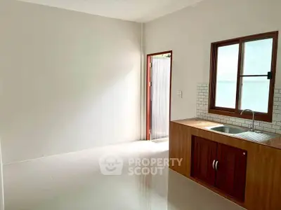 Spacious kitchen with wooden cabinetry and natural light, perfect for culinary enthusiasts.