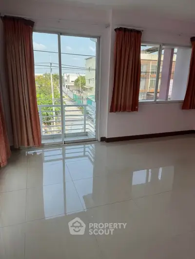 Spacious room with large windows and balcony access, offering a bright and airy atmosphere.