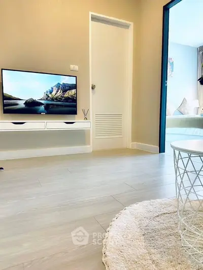 Modern living room with sleek TV setup and cozy decor in stylish apartment.