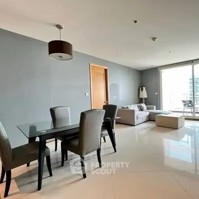 Modern living room with dining area and large windows in a stylish apartment.