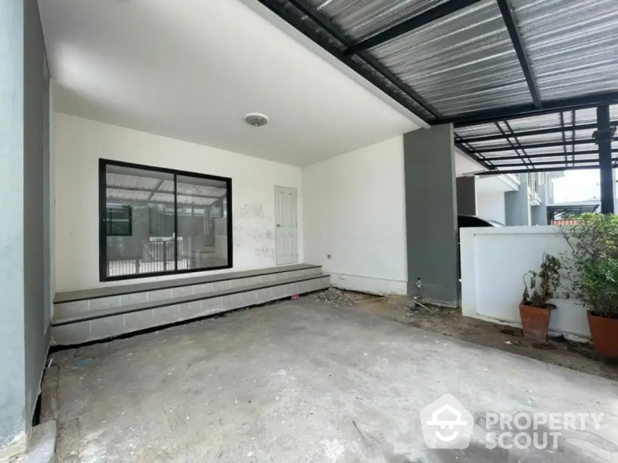 Spacious covered patio area with potential for outdoor living space, featuring large windows and ample natural light.