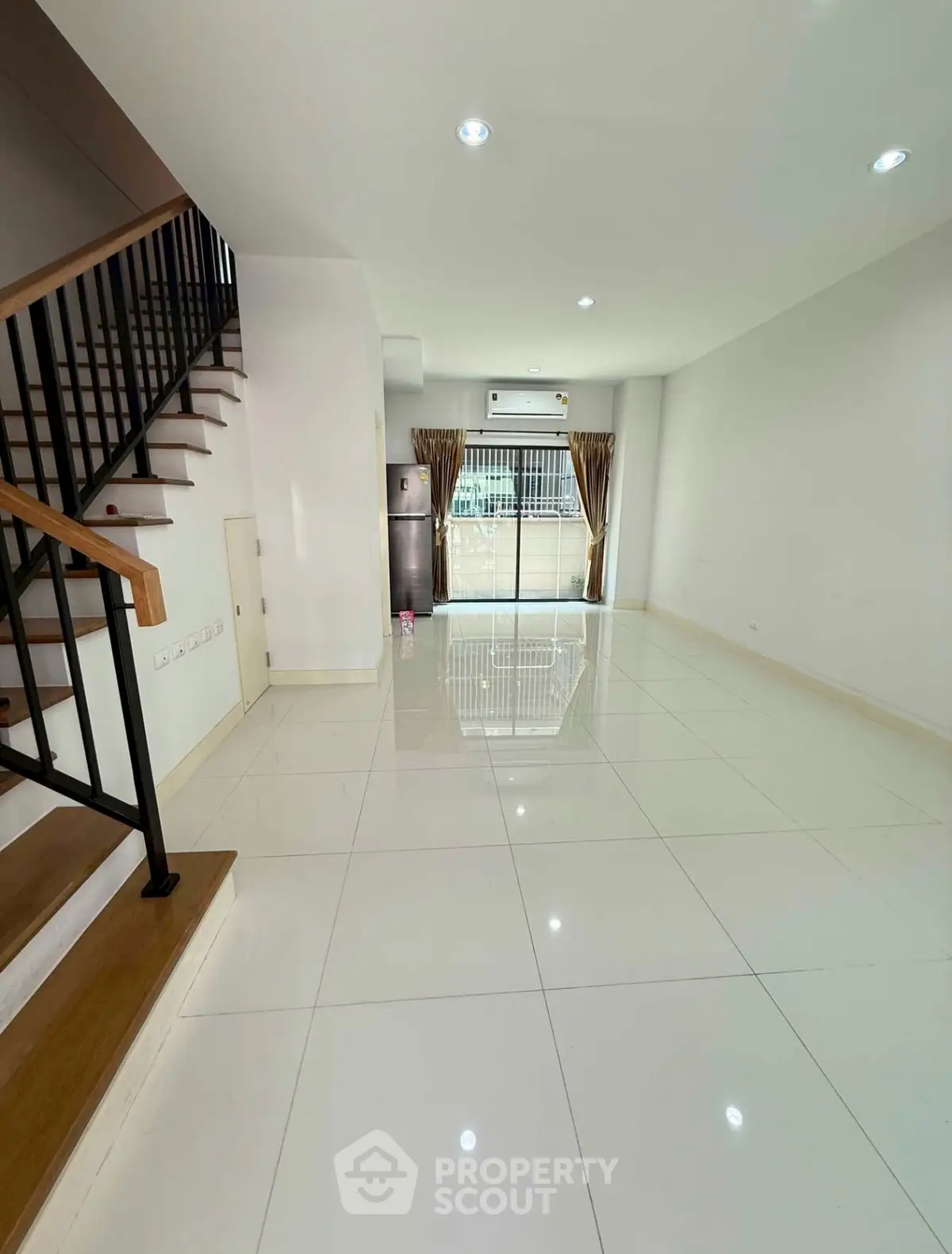 Spacious modern living room with sleek staircase and large windows