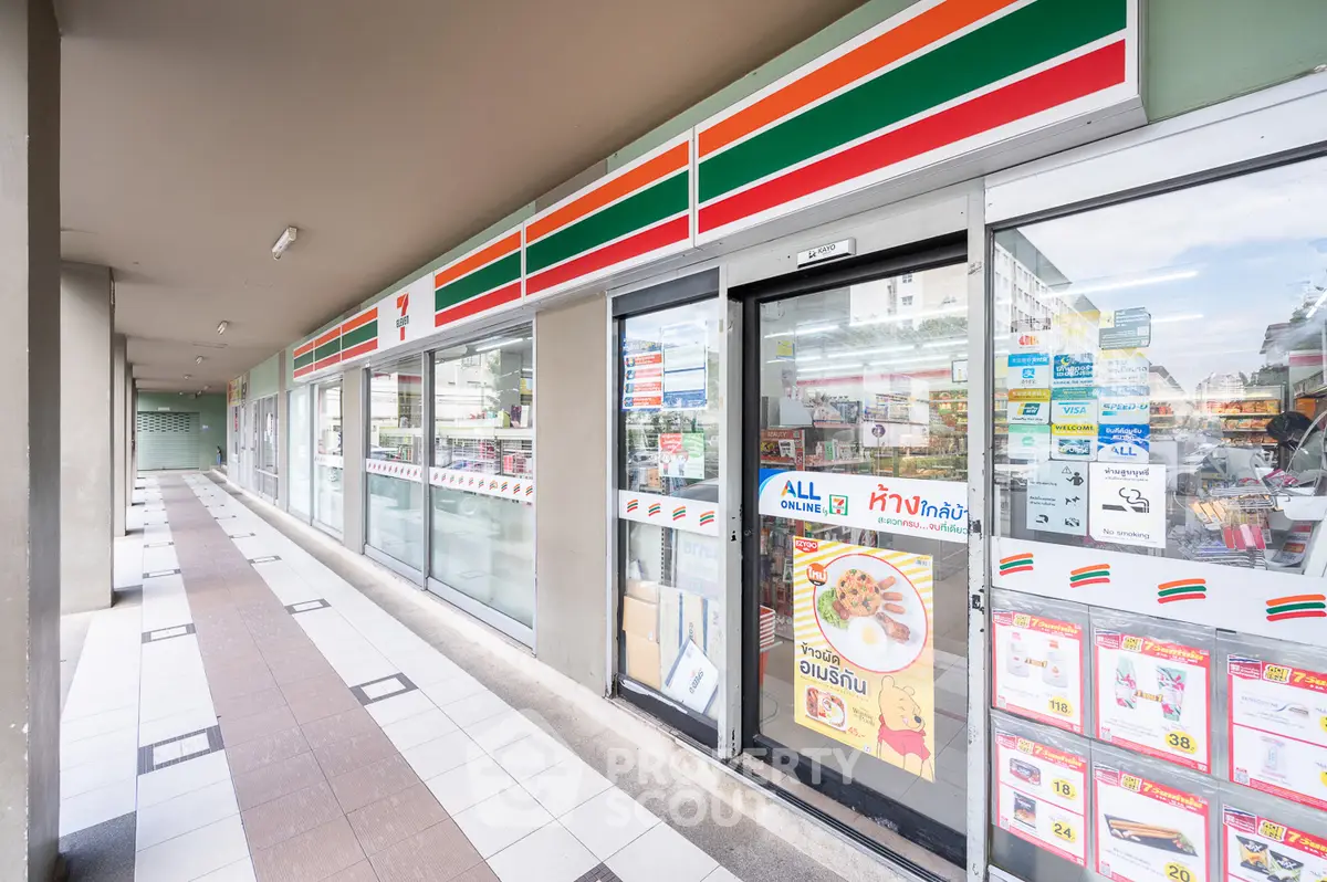 Convenience store exterior with glass windows and colorful signage in a commercial building.