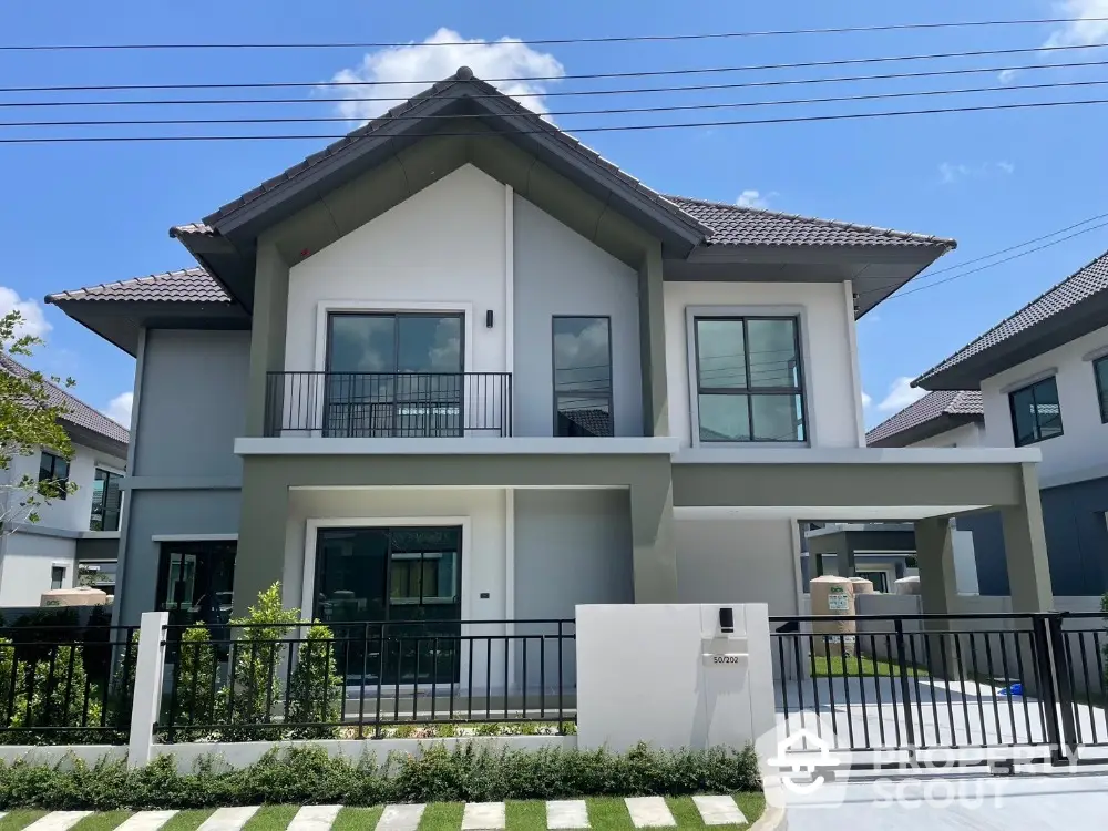 Modern two-story house with sleek design and spacious balcony in a serene neighborhood.