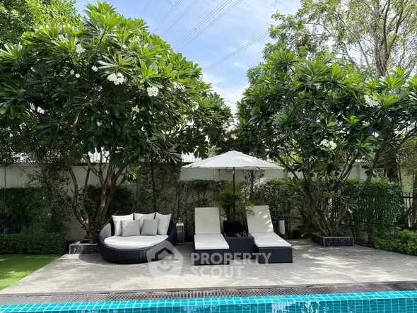 Luxurious poolside oasis with stylish loungers and lush greenery