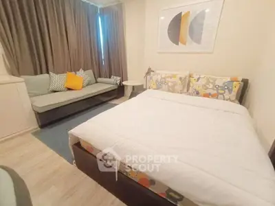 Cozy bedroom with modern decor and comfortable seating area, perfect for relaxation.