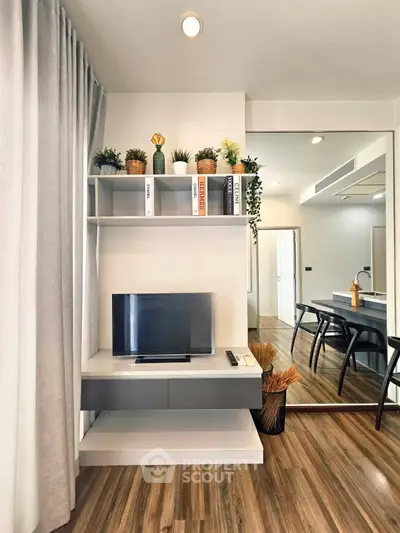 Modern living room with stylish decor, wooden flooring, and sleek furniture for a cozy ambiance.